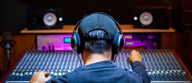 Broadcasting professional using a soundboard.